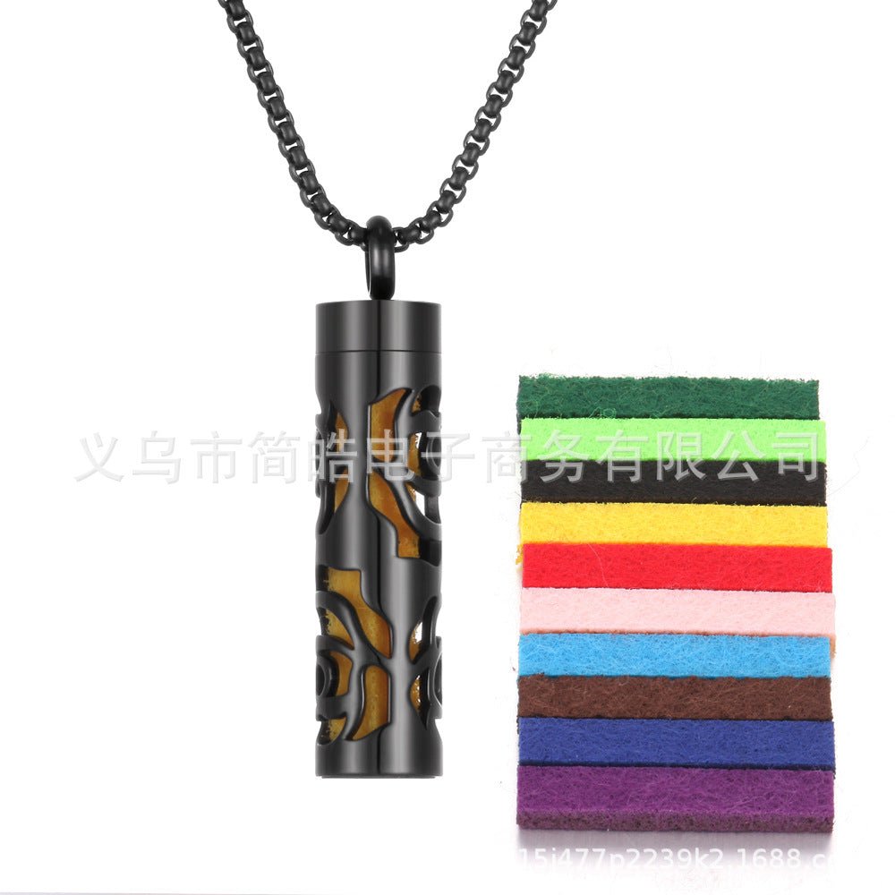 Detail close-up of the aromatherapy pendant in black and orange featuring a stainless steel essential oil bottle.
