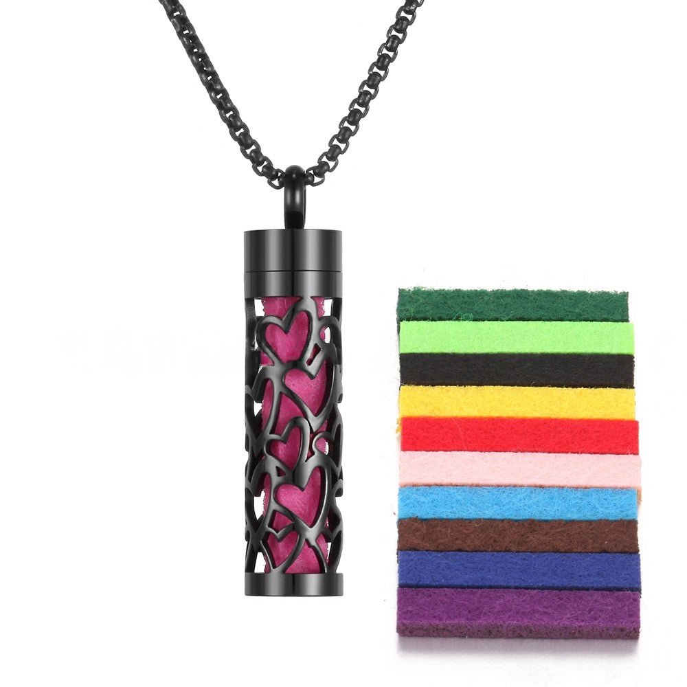 Close-up detail of black stainless steel aromatherapy pendant with chain necklace.
