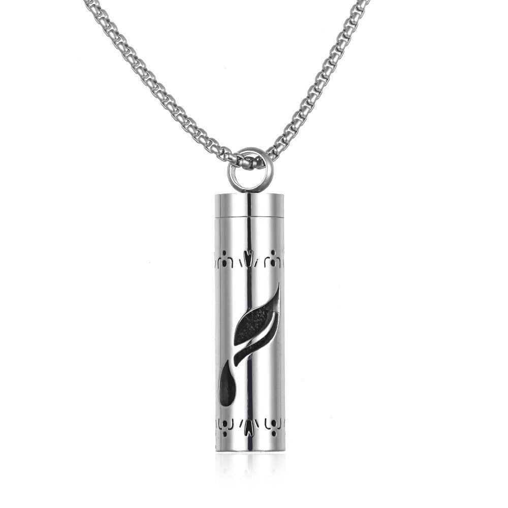 Detail close-up of the stainless steel pendant featuring a leaf design and chain necklace in silver.