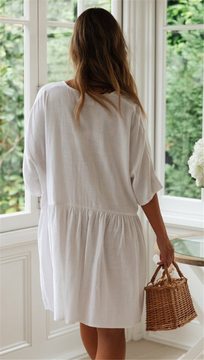 Back view of the white beach blouse featuring a button back and loose fit, elegant addition to any minimalist collection.