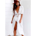 Lifestyle shot of the white beach skirt highlighting a deep V-neck and high slit, ideal for chic beachwear.