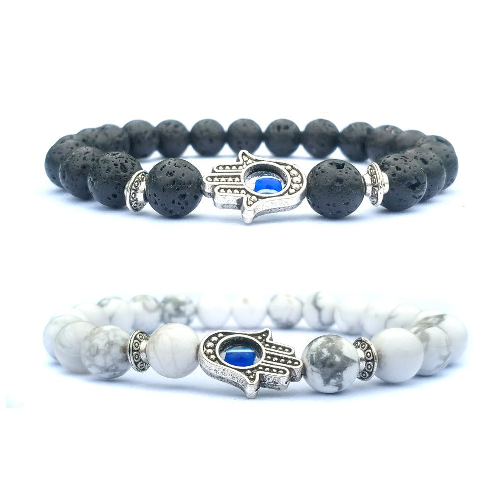 Detail close-up of the black and white stone bracelet featuring an evil eye charm and beaded design.