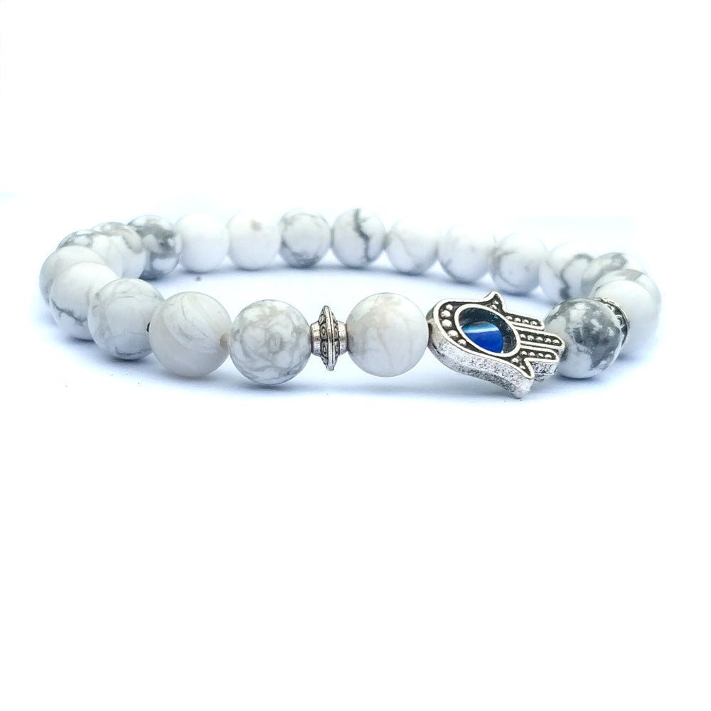 Detail close-up of the white stone bracelet with a chic beaded design and evil eye charm.