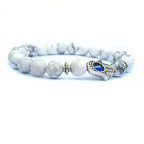 Detail close-up of the white stone bracelet with a chic beaded design and evil eye charm.