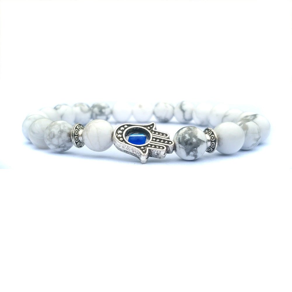 Close-up of the white stone bracelet with a sophisticated beaded design and evil eye charm.