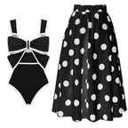 Bikini and skirt set in black and white with polka dots and bow detail, solid background.