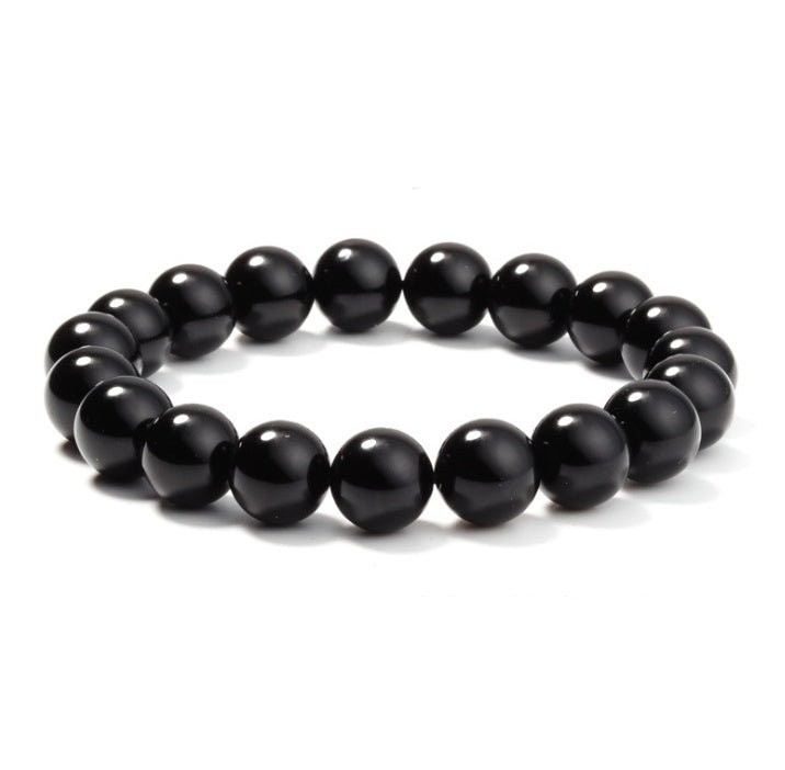 Detail of geometric black onyx bracelet with smooth beads on white background