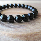 Detail of black onyx bracelet with round beads and smooth finish on natural background