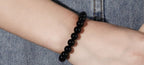 Side view of black onyx bracelet with smooth beads, flexible fit on hand