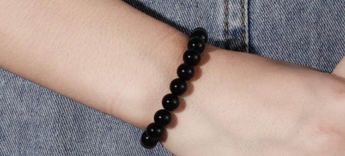Side view of black onyx bracelet with smooth beads, flexible fit on hand