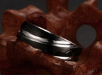 Detail close-up of the black titanium steel ring with a smooth finish on a neutral background.