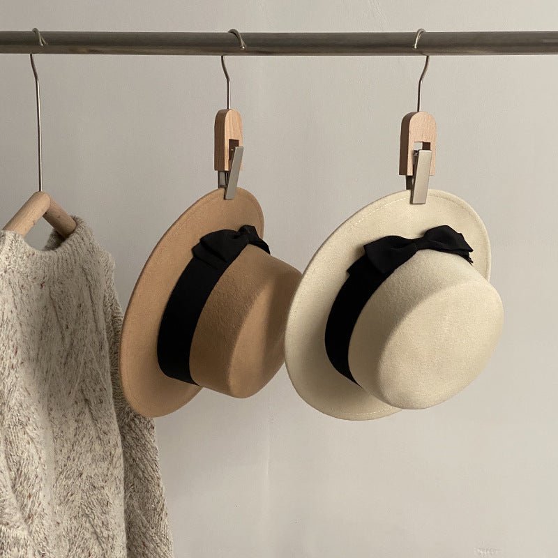 Close-up of a black cap with a bow detail, emphasizing its stylish flat brim and chic design.