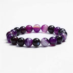 Detail shot of Violet Agate Bracelet with round beads, showcasing purple and black colors on a white background.