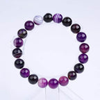 Detail shot of Violet Agate Bracelet with round beads, emphasizing its purple and black colors on a white background.