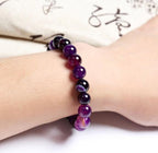 Lifestyle shot of Violet Agate Bracelet worn on wrist, displaying smooth beads in a natural setting.