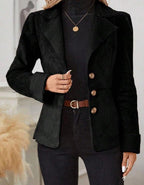 Detail close-up of the black fur jacket featuring integrated lapel and button closure, highlighting chic minimalist design.