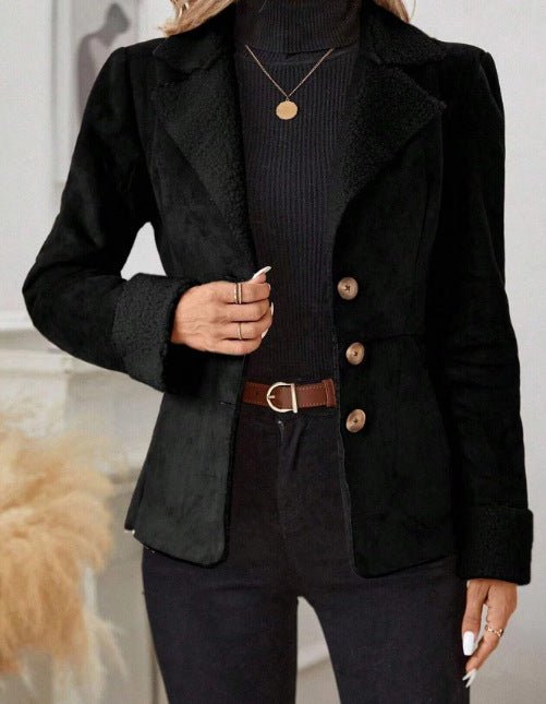 Detail close-up of the black fur jacket featuring integrated lapel and button closure, highlighting chic minimalist design.