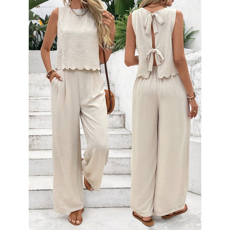 Lifestyle shot of apricot and black casual sleeveless vest and trousers set with back tie detail.