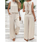 Lifestyle shot of apricot and black casual sleeveless vest and trousers set with back tie detail.