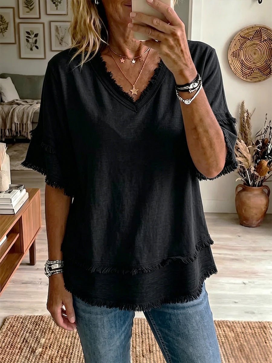 Lifestyle shot of a black pullover shirt with a v-neck and short sleeves, ideal for an elegant minimalist style.