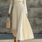 Detail of a cream pleated satin maxi dress with handbag, showcasing elegant minimalist fashion @Black#White