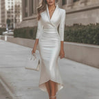 Lifestyle shot of a long white satin dress featuring long sleeves and a V-neck, showcasing chic fashion