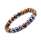 Detail close-up of the yellow and brown tiger eye bracelet with a beaded design and obsidian separator.