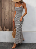 Lifestyle shot of a gray and white striped knitted slip dress, emphasizing spaghetti straps and maxi length.