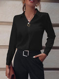 Black long sleeve business shirt with pearl buttons, elegantly displayed in a natural environment.