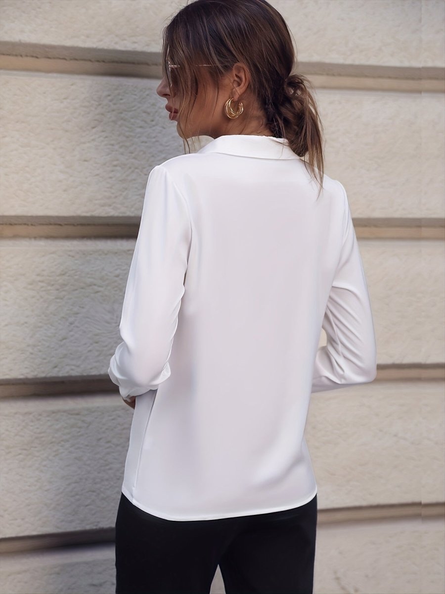 Elegant white long sleeve business shirt with pearl buttons, showcased in a natural backdrop.