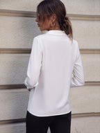 Elegant white long sleeve business shirt with pearl buttons, showcased in a natural backdrop.