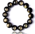 Detail shot of Gold Sapphire Bracelet with round beads, showcasing black and gold colors on a white background.