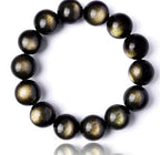 Detail shot of Gold Sapphire Bracelet with round beads, showcasing black and gold colors on a white background.