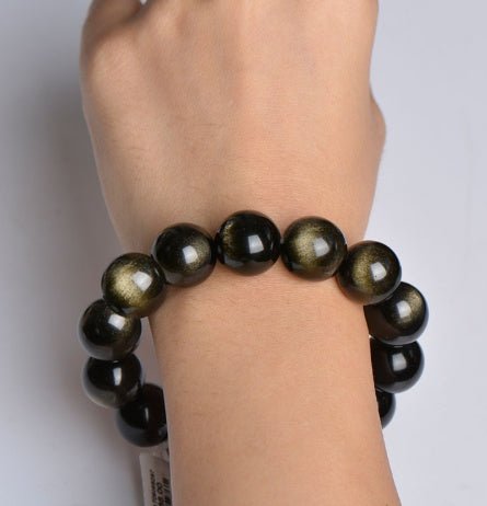 Three Gold Sapphire Bracelets with round beads, displaying black and gold colors on a natural background.