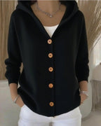 Front view of the black cotton cardigan with button closure and long sleeves, sophisticated minimalist design.