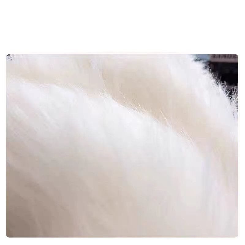 Close-up detail of soft white knitted fabric showcasing its texture.