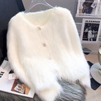 Close-up detail of a white knitted cardigan featuring button closure and fluffy texture.