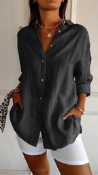 Lifestyle shot of a gray long sleeve cardigan shirt, featuring a pleated design and single-breasted style.