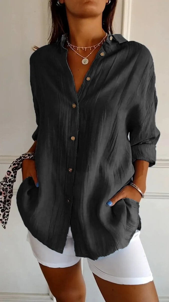 Lifestyle shot of a gray long sleeve cardigan shirt, featuring a pleated design and single-breasted style.