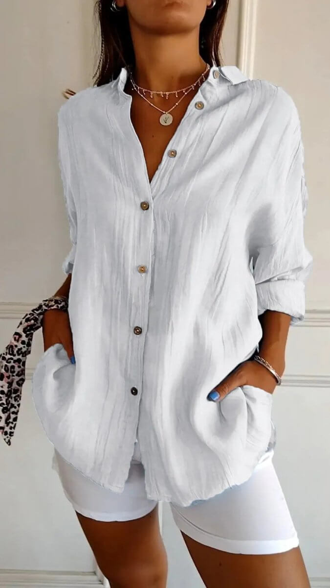 Lifestyle shot of a white long sleeve cardigan shirt, showcasing a pleated design and single-breasted style.