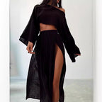 Chic black two-piece suit featuring an off-shoulder top and high slit skirt in a lifestyle shot.