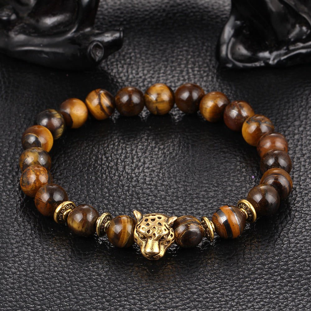 Detail close-up of the black stone bracelet featuring a lion charm, chic accessory for any outfit.