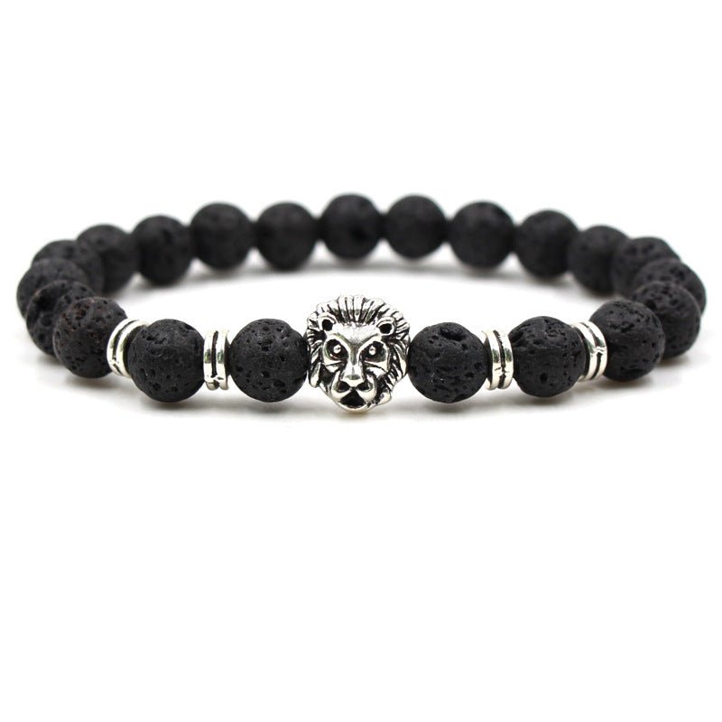 Detail close-up of black stone bracelet with lion head charm, featuring silver accents on white background