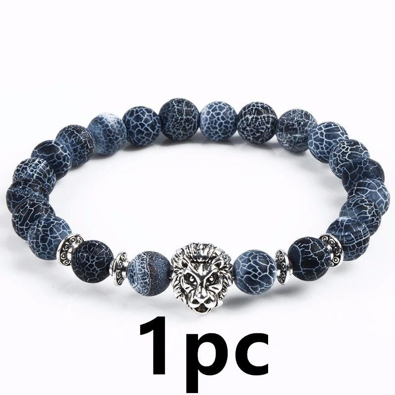 Detail close-up of blue stone bracelet with lion head charm, highlighting beaded design on white background