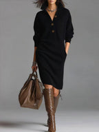 Long black pullover sweater dress with button detail, elegant minimalist style in studio setting.