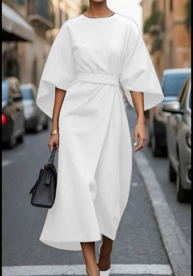 Lifestyle shot of a white batwing sleeve dress featuring waist tie, chic fashion for capsule wardrobe.