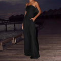 Black backless wide leg jumpsuit in a lifestyle shot, showcasing chic fashion outdoors.