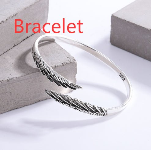 Lifestyle shot of a silver bracelet with angel wings design against a solid color background.