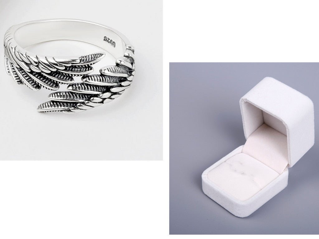 Detail shot of the smooth silver couple ring with a curved shape and angel wings design.