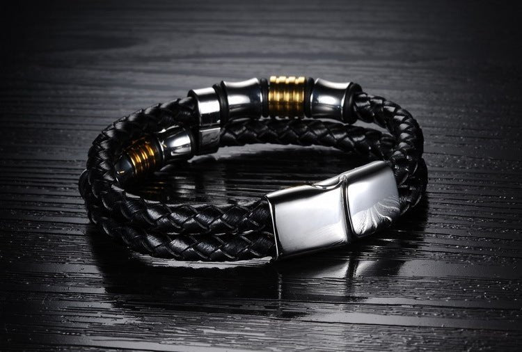 Close-up of the geometric leather bracelet with a smooth finish in black and gold.